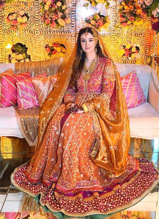 Picture of Minahil Buksh Is Resplendent In A Signature #Farahtalibaziz Kalidaar In Burnt Orange With A Vibrant Magenta Lehnga, Accentuated With Gold Embellishments And A Stunning Gold Dupatta