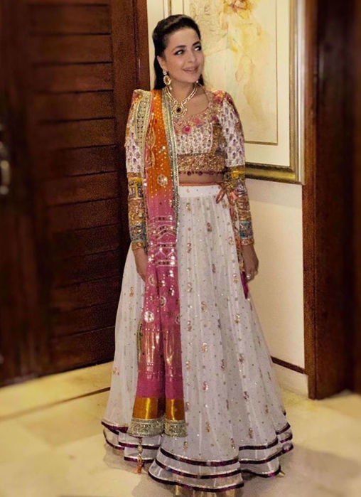 Picture of Our Creative Director Maliha Aziz Jamil, Looks Absolutely Gorgeous In A Stunning Ivory Lehnga Choli Accentuated With A Signature #Farahtalibaziz Chunri Chaddar In Shades Of Burnt Orange And Magenta